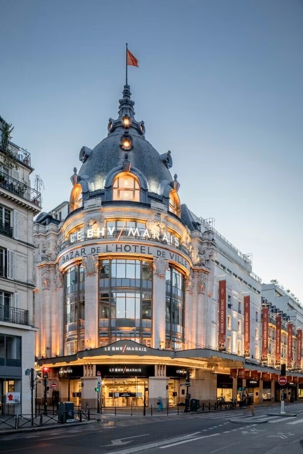 Façade du BHV Marais, un grand magasin emblématique de Paris, avec une architecture ornée et une grande enseigne lumineuse.